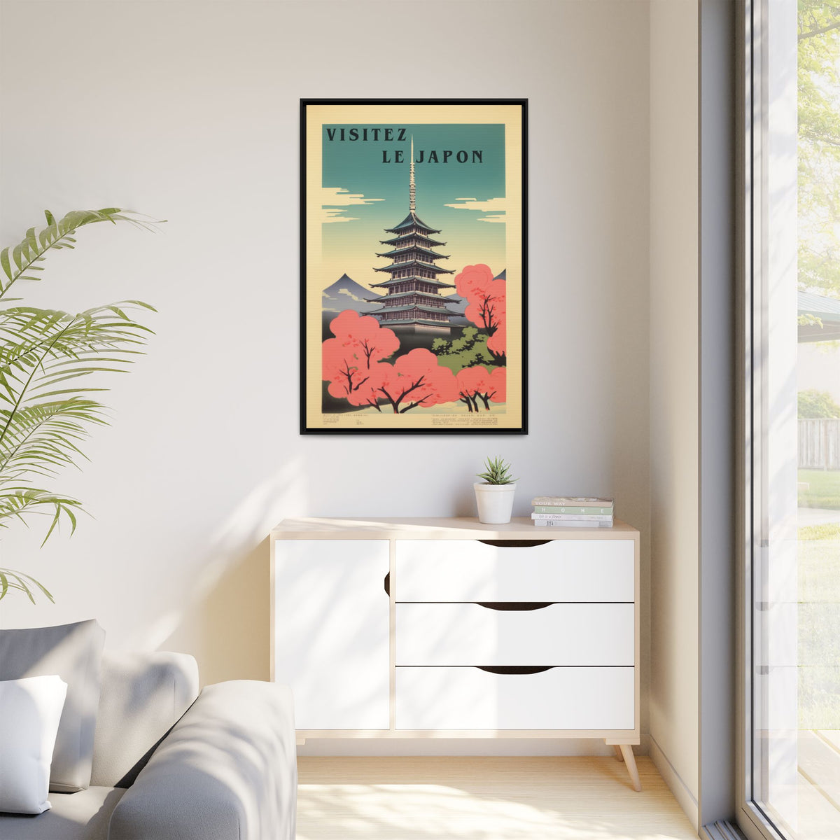 Visitez Le Japon vintage pagoda travel artwork, 32 × 48, black framed canvas, displayed on a white wall above a low cabinet, beside a potted plant in daylight